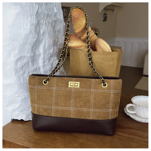 Close-up of caramel suede chain bag with golden turn-lock and contrast stitching