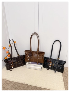 Detail view of large vintage tote bags in brown and black with contrast stitching and charms