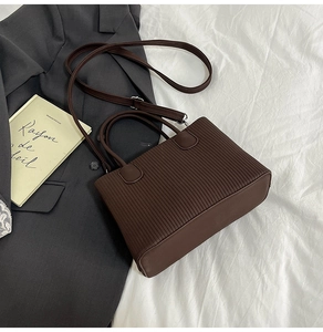 Détail du sac cabas marron foncé avec rayures verticales et garnitures en métal argenté