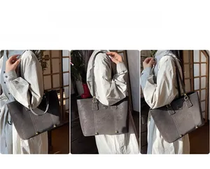 Detailansicht der grauen Shopper-Tasche mit Kontrastnähten und Metallfüßen am Boden