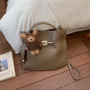 Detail of lychee pattern leather bucket bag with silver lock and bear pendant