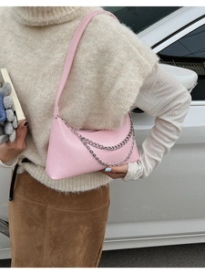 Detailed view of pink leather crossbody bag featuring silver double chain ornaments