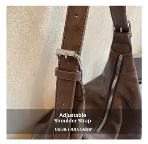 Détail de la bandoulière réglable en cuir avec une boucle en métal argenté brillant