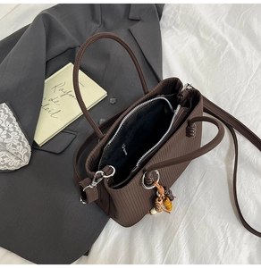 Détail du sac cabas plissé marron avec perles en bois et bandoulière amovible