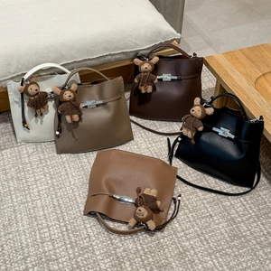 Detailed view of leather bucket bags in five colors with cute bear charms and metal clasps