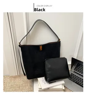 Detail of black suede tote bag with gold hardware buckle and small inner pouch