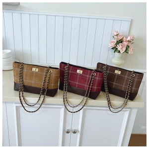 Detail of checkered tote bags in tan and red with gold chain straps and twist-lock