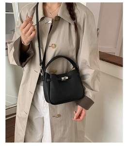 Détail du sac seau en cuir grainé noir avec poignée supérieure et boucle métallique