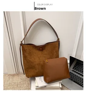 Detail view of brown suede tote bag and matching zipper pouch in an office scene