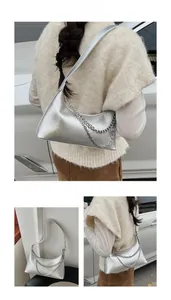 Detail of silver embossed leather shoulder bag with metallic chain strap decoration
