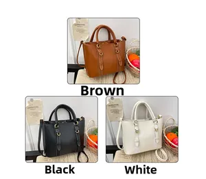 Three leather bucket bags in brown, black and white with gold hardware and top handles
