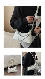 Detail of off-white dumpling bag with double silver chain and adjustable shoulder strap