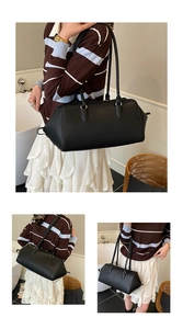 Detail of black lychee grain leather boston bag with silver rings and shoulder strap