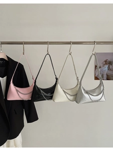 Detail of four colorful croissant bags with chain straps in pink, black, white, and silver