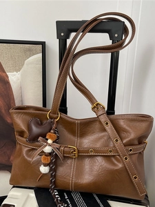 Vintage brown leather tote bag with heart charm and shoulder strap for commute