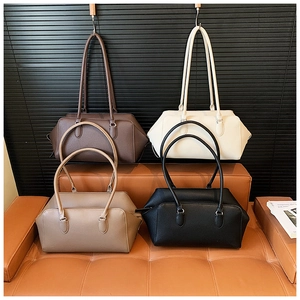 Detailed view of four textured leather bowling bags in brown, white, khaki, and black