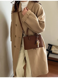 Gros plan du sac marron gaufré avec un pendentif décoratif en perles de bois colorées