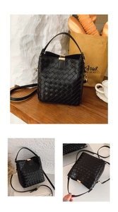 Détail d'un sac seau tressé noir montrant la texture du cuir et le fermoir en métal
