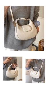 Detail of creamy white crescent shoulder bag with golden hardware and flap design