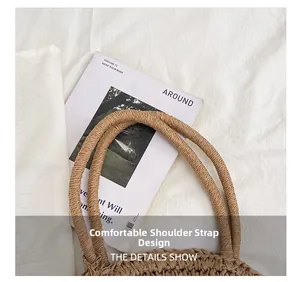 Detail view of woven straw tote with thick round shoulder straps on white linen