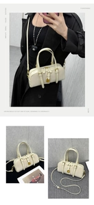 Detail of beige leather Boston bag featuring gold hardware and adjustable shoulder strap