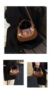 Detail of glossy brown crescent bag with braided strap handle and heart charm detail