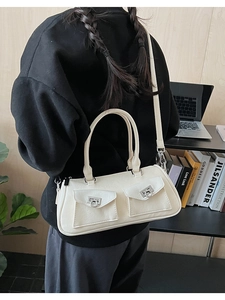 Cream white shoulder bag with front double pockets shown on model in a modern office