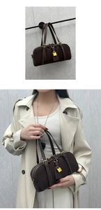 Detail of dark brown leather Boston bag with gold hardware and model carry view