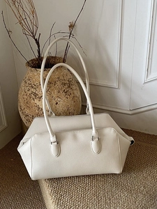 Cream white pebbled leather shoulder bag for women in a minimalist interior setting