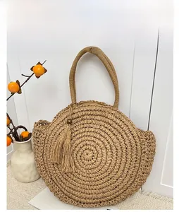 Detail of khaki straw tote bag with concentric weave pattern and long tassel charm