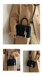 Detail view of black textured square bag with decorative beads and crossbody strap