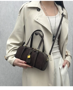 Detail of a vintage dark brown Boston bag with golden padlock and suede texture