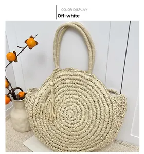 Detail of cream straw handbag showing circular weave texture and elegant tassel accent