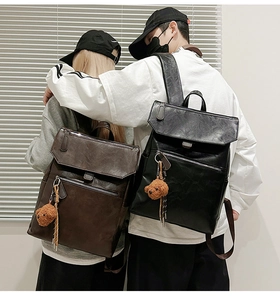 Vue détaillée de sacs à dos rétro en similicuir marron et noir avec breloques d'ours