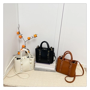 Detailed view of fashionable bucket bags with stitching in beige, black and tan colors