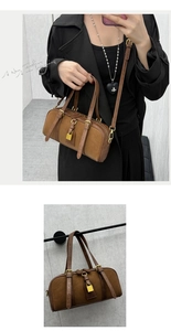 Detail of vintage Boston bag in brown suede and leather with a gold padlock accent