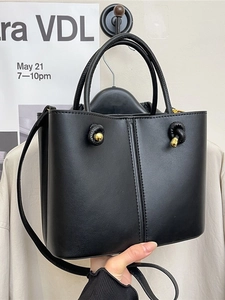 Schwarze Bucket Bag aus Leder mit goldfarbenen Knotendetails und praktischem Tragegriff
