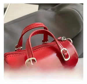 Detalle del mini bolso cilíndrico rojo de cuero PU con herrajes plateados y asas suaves
