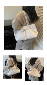Detail view of large cream retro tote bag with buckle decor and shoulder strap