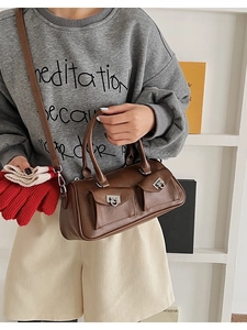 Detailed view of a brown vintage leather boston bag with dual front buckle pockets