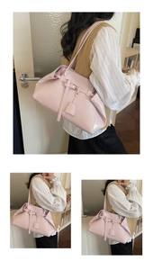 Detail of a light pink glossy leather shoulder bag featuring a stylish buckle and sleek strap