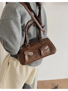 Detail view of dark brown leather bowling bag with vintage pockets and silver buckles