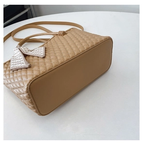 Detail view of khaki quilted texture handbag base with decorative silk scarf