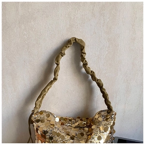 Close-up of golden sequin tote bag with stylish scrunchie strap and metallic finish