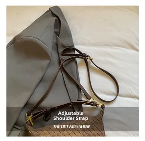 Close-up of woven leather hobo bag with adjustable strap and gold metal buckle