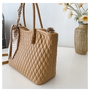 Detail of camel quilted tote bag with silk scarf and high-quality stitch texture