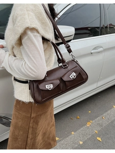 Detail of dark brown leather shoulder bag with glossy finish and front flap pockets