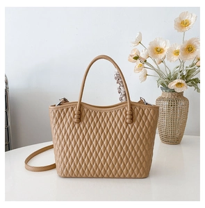 Close-up of khaki quilted tote bag with floral scarf detail on the handle for women