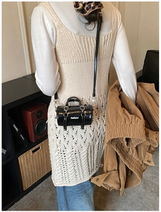 Vista de detalle del bolso cilíndrico negro mini con estampado Hellojm y cierres plateados