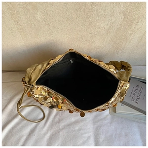 Fashionable gold sequin handbag with round metallic discs and satin pleated handle